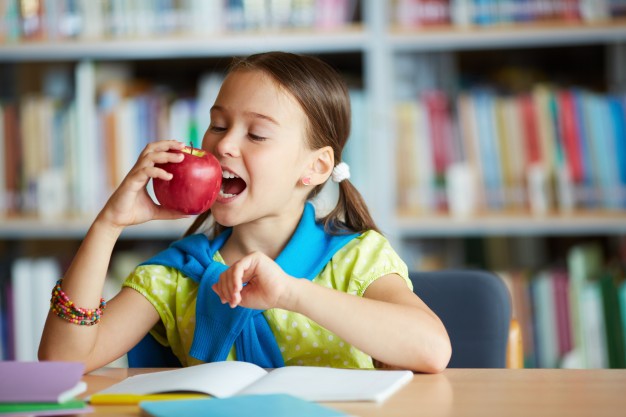 schoolgirl biting an apple in the library 1098 2597